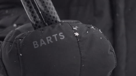 Swiss-alps-equipment-of-a-skier,-gloves-with-falling-snowflakes