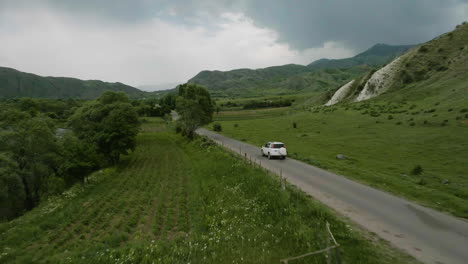 Vehículo-Suv-Conduciendo-En-Una-Carretera-Vacía-A-Lo-Largo-De-La-Pradera-Verde-En-Aspindza-En-Georgia