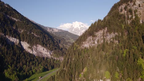 Aerial-drone-footage-raising-up-revealing-beautiful-views-of-snowy-mountain-peaks-Wetterhorn,-Schreckhorn,-Eiger,-Moench-and-Jungfrau-in-Grindelwald,-Switzerland