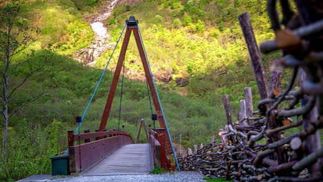 Timelapse-footage-of-tourists-taking-photos-while-walking-on-a-wooden-over-bridge-along-a-hilly-terrain-at-daytime