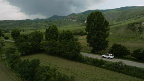 Car-Travelling-On-The-Road-Through-Cultivated-Farm-Fields-With-Overcast-Near-Aspindza-In-Georgia