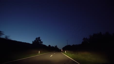 A-POV-shot-driving-through-a-country-lane-at-night