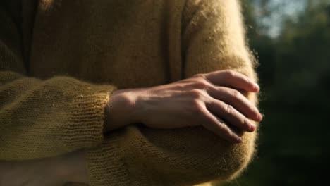 Female-hand-touching-soft,-yellow-sweater-from-wool-in-sunlight