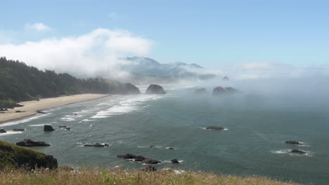 Morning-mist-over-Pacific-Ocean-as-waves-break-on-Crescent-Beach,-Ecola-State-Park