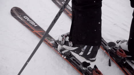 Slow-motion:-a-pair-of-skis-is-thrown-on-a-flat-snowy-ground-dedicated-to-the-practice-of-winter-sports