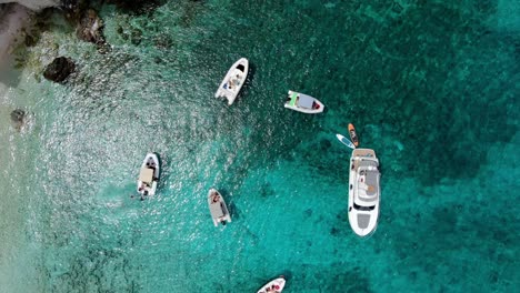 Drohnenaufnahmen-Von-Der-Insel-Tremiti-Zeigen-Viele-Boote-Und-Eine-Yacht,-Die-Im-Kristallklaren-Blauen-Wasser-Treiben