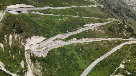 Grimselpass-backwards-aerial-movement-showing-perspective-of-the-famous-curvaceous-road-in-Switzerland