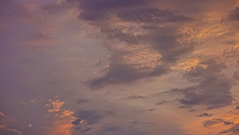 Low-Angle-Shot-Von-Weißen-Und-Dunklen,-Flauschigen-Wolkenbewegungen-Im-Blauen-Himmel-Während-Des-Sonnenuntergangs