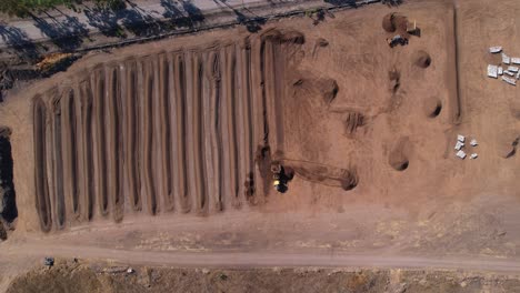 Aerial-drop-down-of-a-yellow-tractor-processing-compost-mixture-on-a-farm-in-mexico