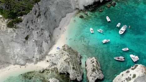Drone-footage-of-Tremiti-island-in-Italy-shows-the-cliff-and-the-sea's-brilliant-blue-color,-where-several-boats-and-yachts-are-sailing