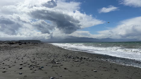 Dramatic-clouds-passing-over-Olympic-Peninsula-as-ocean-waves-lap-onto-beach-shoreline