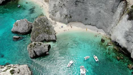 Tremiti-Island-in-Italy-has-a-white-sand-beach-and-gorgeous,-clear-waters-of-the-Adriatic-Sea-where-boats-cruise-and-people-wander-along-the-shore