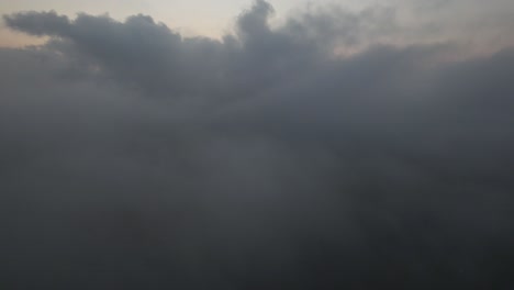 Eine-Luftaufnahme-über-Den-Wolken-Während-Eines-Nebligen-Sonnenaufgangs