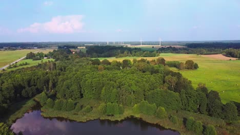 Panorama-Del-Lago-De-La-Ciudad-De-Alsunga-Con-Grandes-Turbinas-Eólicas-Para-La-Producción-De-Energía-Eléctrica-En-Letonia-1