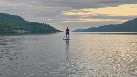 Young-Woman-In-A-Wetsuit-Standing-Up-On-A-Stand-Up-Paddleboard-On-Loch-Ness