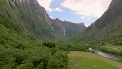 Natural-green-valley-with-small-river-in-iconic-Norwegian-landscape,-Gudvangen