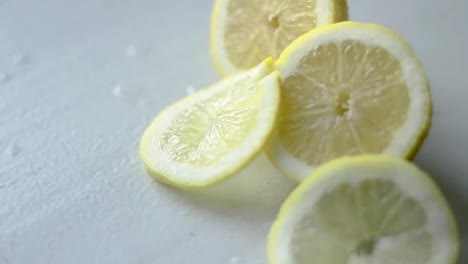 Slice-Zitronenfrucht-Auf-Dem-Tisch-Mit-Weißem-Hintergrund-Stock-Footage