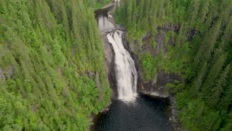 Storfossen-waterfall-with-powerful-water-rushing-down-rocky-cliff,-aerial