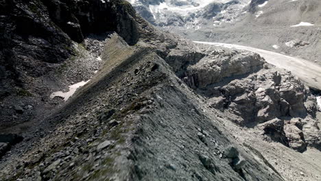 Aerial-FPV-like-shot-moving-forward-tracing-the-shape-of-the-mountain-with-a-glacier-in-the-background-in-Zinal,-Switzerland