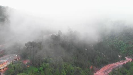 Aerial-View-Of-Dense-Mist-Above-Green-Hillside-In-Punjab