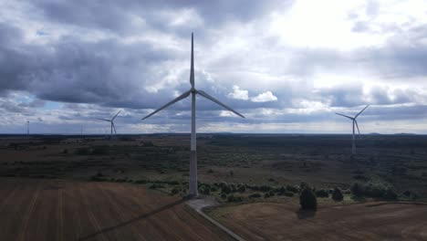 Windkraft-Auf-Einem-Feld-An-Einem-Sonnigen-Tag,-Drohnenaufnahme-4k
