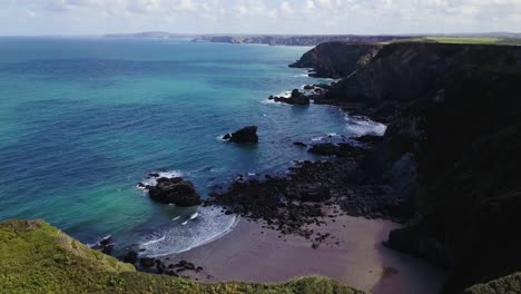 Cliffs-And-Turquoise-Ocean-Of-Godrevy-Beach-In-Cornwall,-England---drone-shot