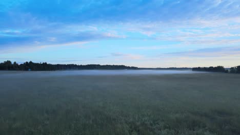 Sunset-drone-shot-with-fog-on-field-4K