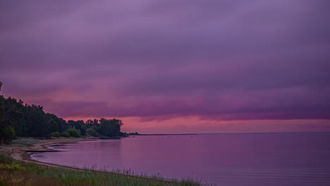 Mystic-dark-clouds-flying-over-ocean-sand-beach-after-pink-sunset---time-lapse