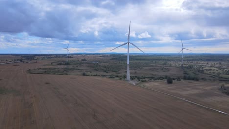 Flying-drone-around-windmills-in-Estonia-with-beautiful-sky,-August-day-4K,-wide-shot