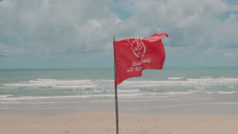 Leerer-Tropischer-Sandstrand-Mit-Roter-Fahne,-Gefahr,-Kein-Schwimmverbot,-Bewölktes-Wetter
