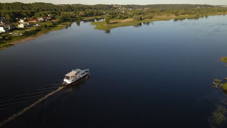 Aerial-shot-of-a-ferry-boat-sailing-on-river-Nemunas-with-beautiful-nature-near-Kaunas,-Lithuania-2