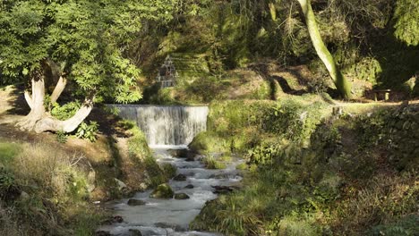 Agua-Que-Fluye-Rápidamente-En-La-Ladera-Rocosa-De-Una-Pequeña-Cascada-En-El-Pueblo-De-St-Stephen,-Cornwall,-Inglaterra,-Reino-Unido