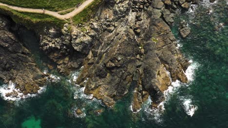 Ocean-Waves-Hitting-Rocky-Shore-At-St-Ives-In-Cornwall,-England---aerial-top-down