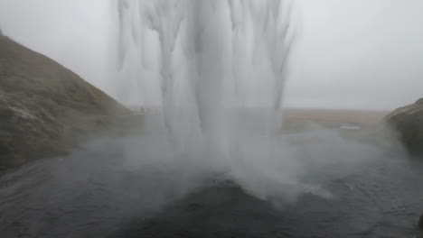 Filmaufnahme-Hinter-Dem-Isländischen-Wasserfall-Seljalandsfoss-Und-Wo-Eine-Frau-Die-Schönheit-Und-Kraft-Des-Fallenden-Wassers-Bewundert