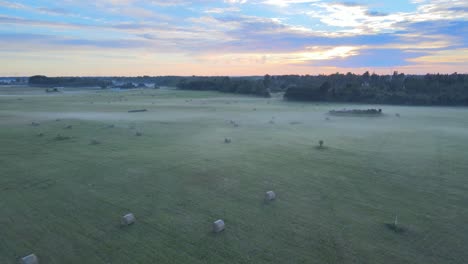 Haystacks-on-a-green-field-at-summer-sunset-4K
