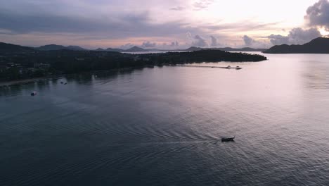 Drone-aerial-over-Thailand-during-sunrise-with-boat-driving-on-the-ocean-Parallax-with-clouds