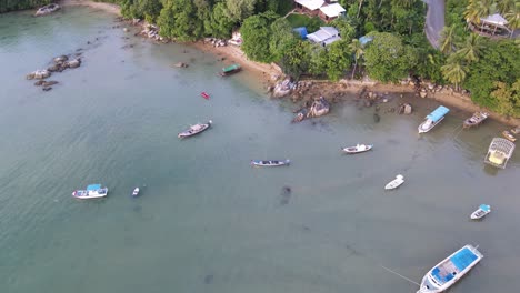 Drone-aerial-pan-down-and-rise-over-tropical-blue-water-in-Thailand-with-speedboats-in-the-water