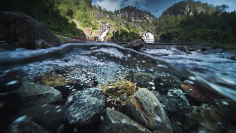 An-over-under-shot-of-the-fast-flowing-shallow-river-with-a-rocky-bottom