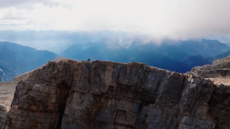 Group-of-active-Rock-Climber-arriving-mountaintop-of-Monte-Pelmo-during-sunny-and-cloudy-day-in-ITaly---Breathtaking-drone-orbit-shot---Group-of-hiker-walking-on-extreme-path-along-peak