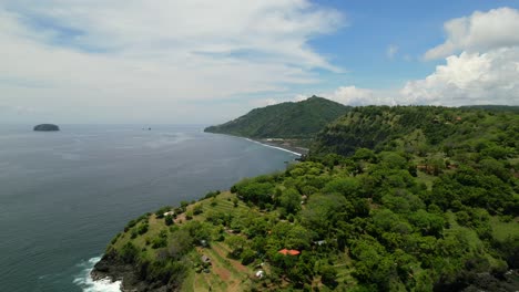 Beautiful-green-mountain-hill-coastline-in-East-Bali-on-a-sunny-day,-aerial