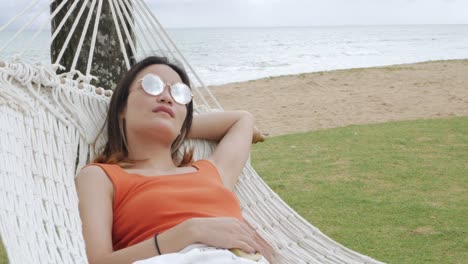 Mujer-Asiática-Relajándose-Y-En-Una-Hamaca-Cerca-De-La-Playa-Bajo-Un-Cocotero-En-Vacaciones