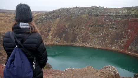 Toma-Cinematográfica-De-Una-Mujer-Admirando-El-Lago-Del-Cráter-Kerid-En-Islandia