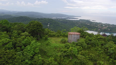 Aerial-view-rising-over-the-crest-of-a-the-Drapers-hillside-to-reveal-Port-Antonio-in-the-distance-with-navy-island-as-the-camera-continues-to-pan-down-onto-the-valley-below