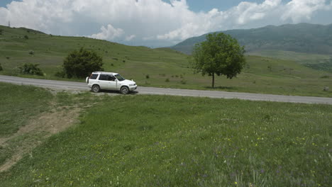 White-Car-Parked-In-Country-Road-Between-Grass-Field-Outside-Aspindza-In-Southern-Georgia