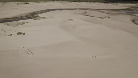 Aerial-shot-over-the-sandy-bottom-of-the-big-river-dried-due-to-the-drought-caused-by-global-warming-and-water-shortage-in-Europe---trucking-left