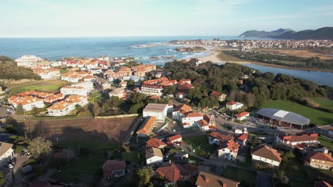 Aerial-view-of-isla,-a-small-village-in-the-town-of-cantabria-and-in-the-background-noja-and-huge-waves