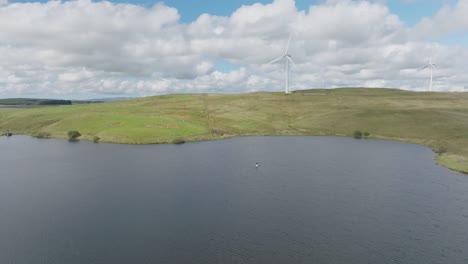 Closing-Shot-Of-A-Young-Woman-Paddling-On-Loch-White-With-Windmills-Turning-In-The-Background