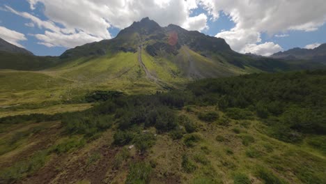 Schnelle-Fpv-antenne,-Die-über-Den-Talboden-Des-Silvretta-stausees-Und-Den-Schotterweg-Entlang-Des-Berges-Fliegt