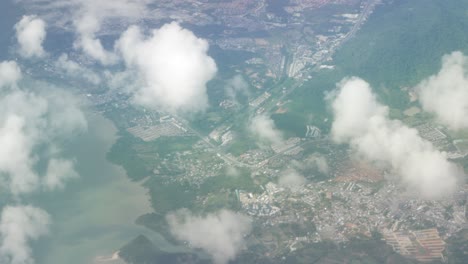 Naturwolkengebilde-über-Der-Wolke-über-Dem-Himmel-Mit-Land-Vom-Fliegenden-Flugzeug