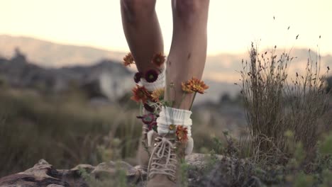Woman-is-hiking-with-boots-artificially-decorated-with-flowers